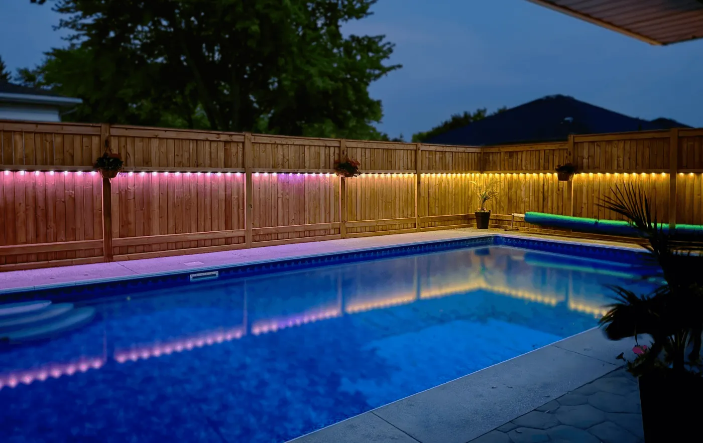 Colorful lighting beside a backyard pool